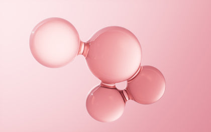 Rose gold ball-shaped object on a pink background