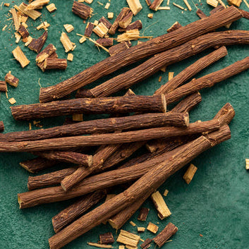 Dried licorice roots on a textured green surface
