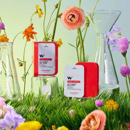 Wizard Wellness products with flowers and vases on a grassy background